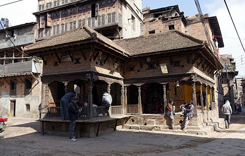 Local residents relaxing and playing cards at a rest house, Bhaktapur, Nepal